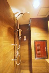 a shower in a bathroom with a wooden wall at T Hostel @ Victory Monument in Bangkok
