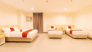 um quarto de hotel com duas camas e uma cadeira em RedDoorz Plus @ Kaizen Suites Taft Avenue em Manila