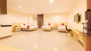 um quarto de hotel com duas camas e uma secretária em RedDoorz Plus @ Kaizen Suites Taft Avenue em Manila