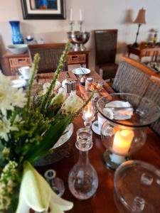a wooden table with candles and flowers on it at Bergview Guesthouse Swellendam in Swellendam +19 photos