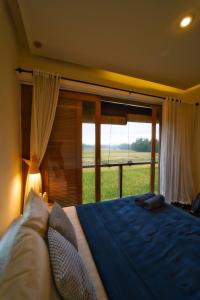een slaapkamer met een groot bed en een groot raam bij Casa Avana in Ubud