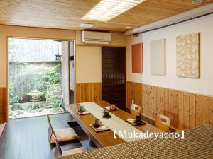 ein Esszimmer mit einem Tisch, Stühlen und einem Fenster in der Unterkunft Kyoisuke in Kyoto