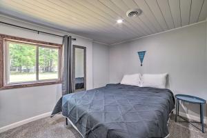 1 dormitorio con cama y ventana en Prudenville Retreat with Yard about 1 Mi to Lake!, en Houghton Lake
