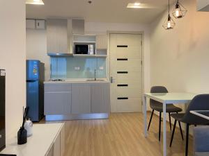 a kitchen and dining room with a table and a refrigerator at Breezy room with balcony view Sukhumvit77 in Bangkok