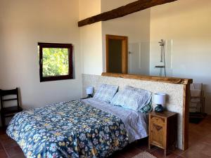 a bedroom with a bed with a blue comforter and a window at Casa da Belavista in Vilar de Nantes