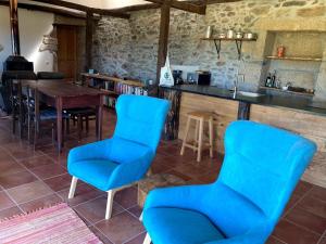 a kitchen with blue chairs and a table at Casa da Belavista in Vilar de Nantes