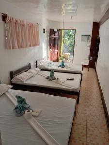 Un grupo de 4 camas en una habitación en RedDoorz @ Isla Virginia Beach Resort Aurora Baler, en Baler