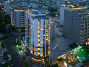 una vista aérea de un edificio blanco alto con luces encendidas en Menora Premium Da Nang - Sea Corner Boutique, en Da Nang