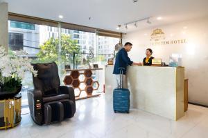 a man and a woman standing at a counter at Menora Premium Da Nang - Sea Corner Boutique in Danang