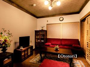 a living room with a red couch and a tv at Kyoisuke in Kyoto