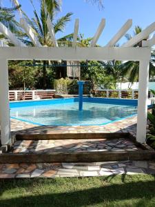 una piscina con pérgola blanca y una piscina en RedDoorz @ Isla Virginia Beach Resort Aurora Baler, en Baler