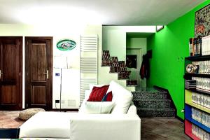 sala de estar con sofá blanco y paredes verdes en Tavernetta con camino in collina en Pianoro