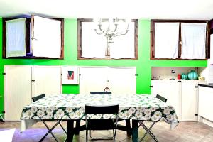 a dining room with a table and a green wall at Tavernetta con camino in collina in Pianoro