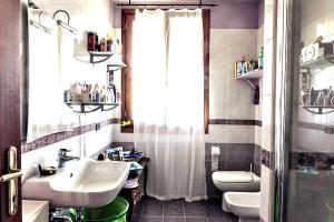 baño con lavabo y aseo y ventana en Tavernetta con camino in collina, en Pianoro