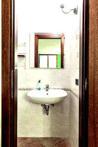 a bathroom with a white sink and a mirror at Tavernetta con camino in collina in Pianoro