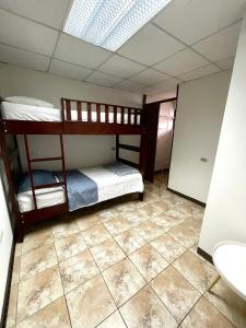 a room with two bunk beds and a tiled floor at Hermoso apartamento en la capital de Costa Rica in San José