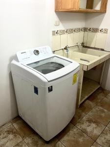 a washing machine sitting in a kitchen next to a sink at Hermoso apartamento en la capital de Costa Rica in San José