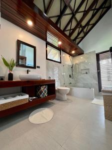 ein Bad mit einem Waschbecken, einem WC und einer Dusche in der Unterkunft Sandy Feet Siargao in General Luna
