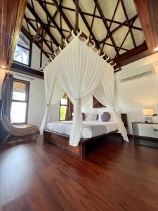 a bedroom with a bed with a canopy at Sandy Feet Siargao in General Luna