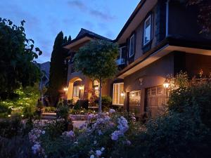a house with a garden in front of it at Summer Express Kelowna B&B - Villa Bellissimo Fran-Talia in Kelowna