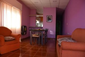 a living room with purple walls and a table and chairs at Luisito in Santa Rosa
