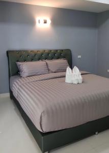 ein großes Bett mit zwei weißen Kissen darauf in der Unterkunft โคซี่ โฮมสเตย์ in Suan Phung