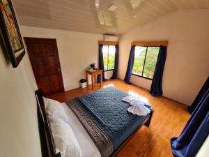 德雷克的住宿－Osa Corcovado Lodge，一间卧室设有一张床和两个窗户。