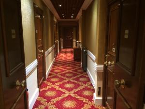 a hallway with a red carpeted floor and doors at Hotel Splendid in Cannes