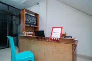a lobby with a counter with a blue chair at RedDoorz @ Aralia Harapan Indah in Pulokendal