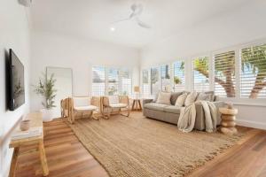 a living room with a couch and a table at Fuller Holidays - Hacienda, Luxury 5 bedroom home with pool in Byron Bay