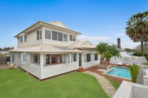 a white house with a pool and a yard at Fuller Holidays - Hacienda, Luxury 5 bedroom home with pool in Byron Bay