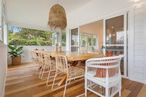 a dining room with a wooden table and chairs at Fuller Holidays - Hacienda, Luxury 5 bedroom home with pool in Byron Bay