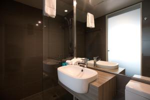 a bathroom with a sink, mirror, and bathtub at Noosa Shores Resort in Noosa Heads