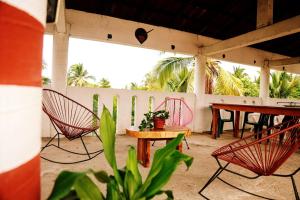 a patio with chairs and a table and a table at Hotel Yurimar in Puerto Escondido