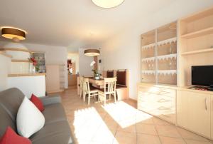a kitchen and living room with a couch and a table at Mason La Zondra in Vigo di Fassa
