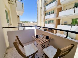 un balcone con 2 sedie e un tavolo su un edificio di Dock Holiday Apartment a Larnaka