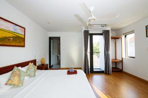 1 dormitorio con cama blanca y ventana en Beach Forest Villa, An Bang, Hoi An, en An Bàn (2)
