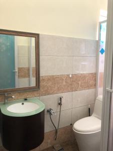 ein Badezimmer mit einem Waschbecken, einem WC und einem Spiegel in der Unterkunft One-Room Homestay 81B Muar in Muar