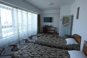 マンガリアにあるMotel Nordianaのベッド2台と大きな窓が備わるホテルルームです。