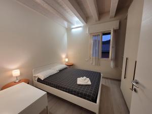 a small bedroom with a bed and a window at Garda view - Nuovo appartamento con solarium vista lago in Garda