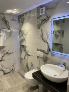 a bathroom with a sink and a toilet at Dani's Apartments in Sarandë +66 photos
