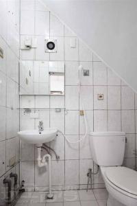 a white bathroom with a toilet and a sink at Haus 19 in Puli