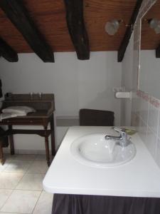a bathroom with a white sink and a table at Chambres d'hôtes Les Pieds dans l'herbe in Saint-Julien-Gaulène