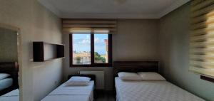 a small room with two beds and a window at İnce Apart Rezidence in Trabzon