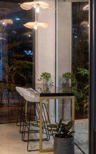 une salle à manger avec une table en verre et une plante en pot dans l'établissement All Are Welcome Lawas Boutique Hotel, à Lawas