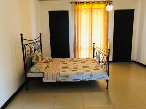 a bed sitting in a room with a window at Cinnamon Villa in Matara