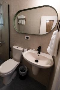 a bathroom with a toilet and a sink and a mirror at Julia's Hotel Suites in Amman