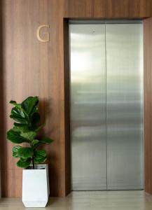 a potted plant sitting in front of a elevator at All Are Welcome Lawas Boutique Hotel in Lawas