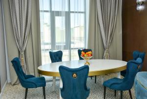a dining room with a table and blue chairs at Ramada by Wyndham Turkistan in Türkistan