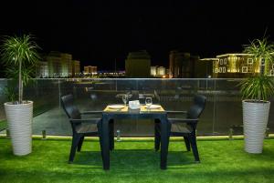 a black table and chairs with a view of the city at Ramada by Wyndham Turkistan in T&uuml;rkistan